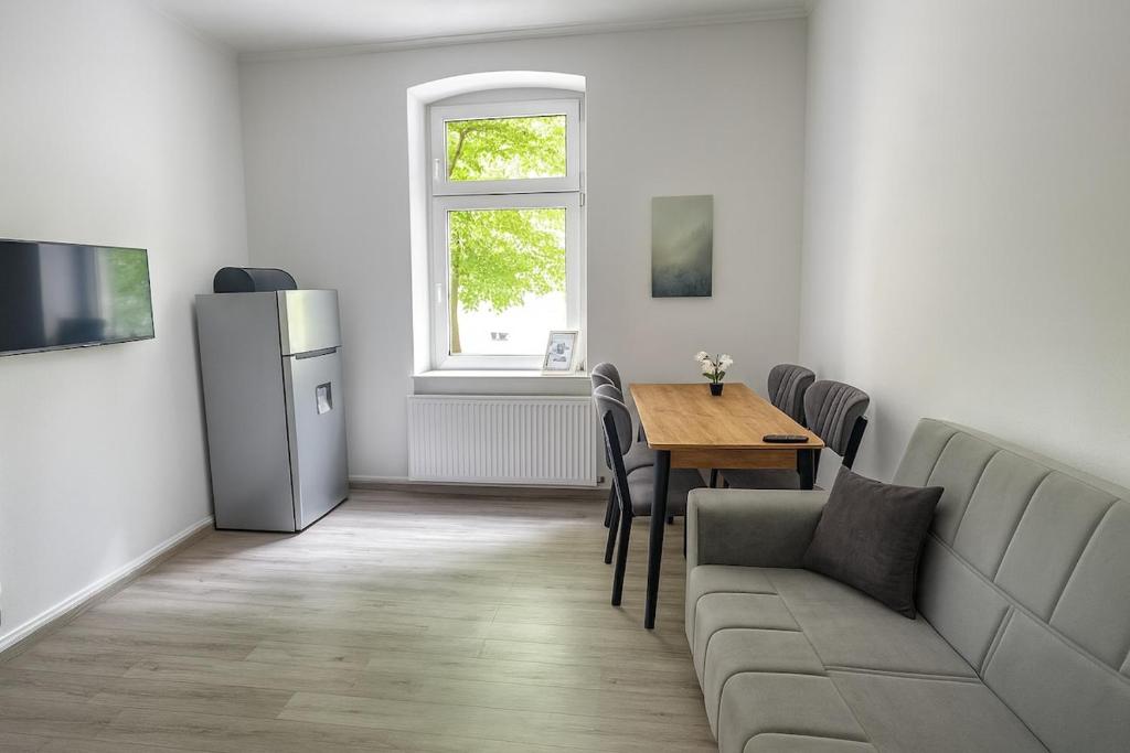 Wohnbereich mit Flachbild-TV und Schreibtisch im Apartment 1 in Herten